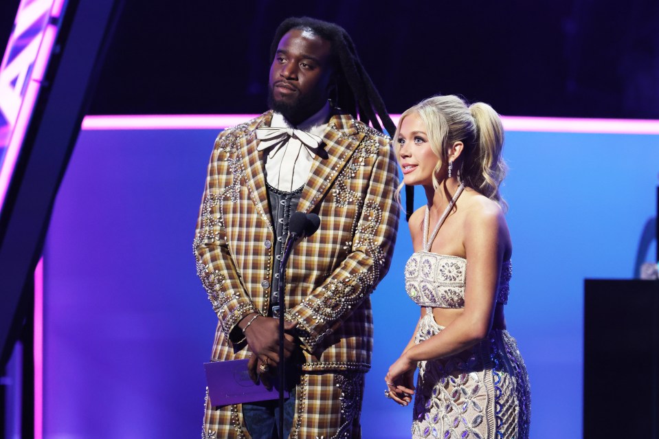 Megan Moroney and a male presenter at the American Music Awards.