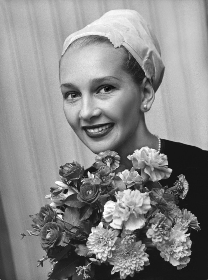 Black and white portrait of a woman holding a bouquet of flowers.