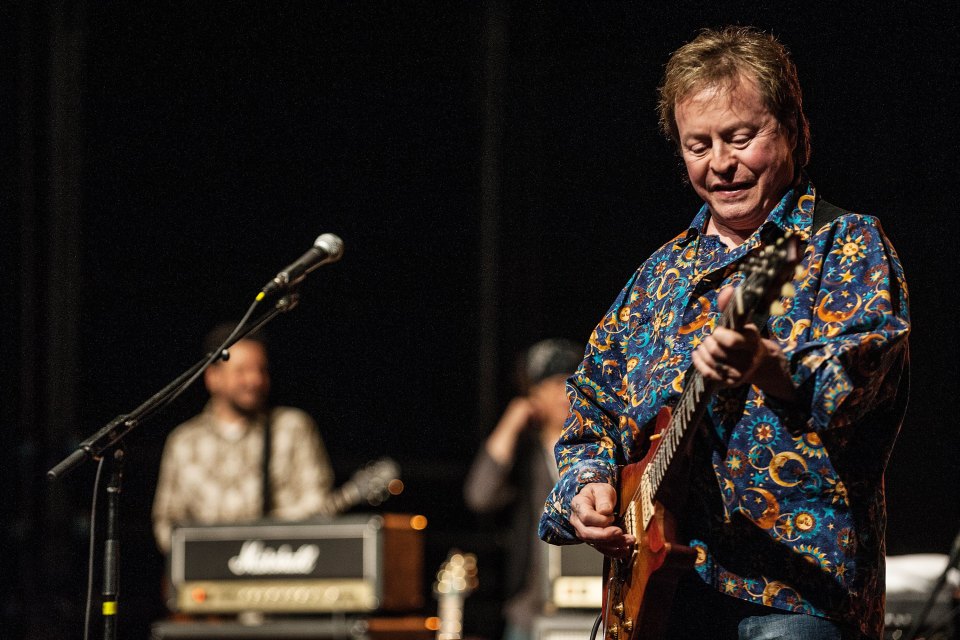 Rick Derringer playing guitar on stage.