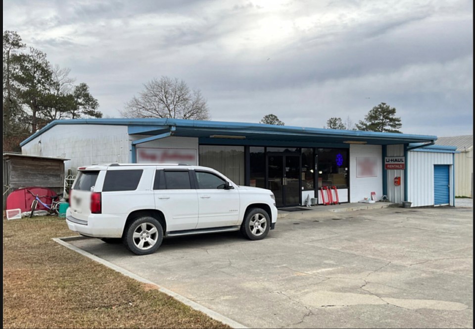 White SUV parked outside a U-Haul rental location.