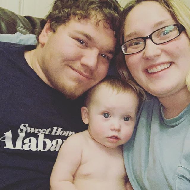 Photo of a family: a man, woman, and baby.