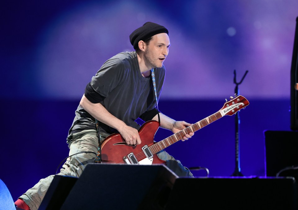 Josh Klinghoffer playing guitar onstage.
