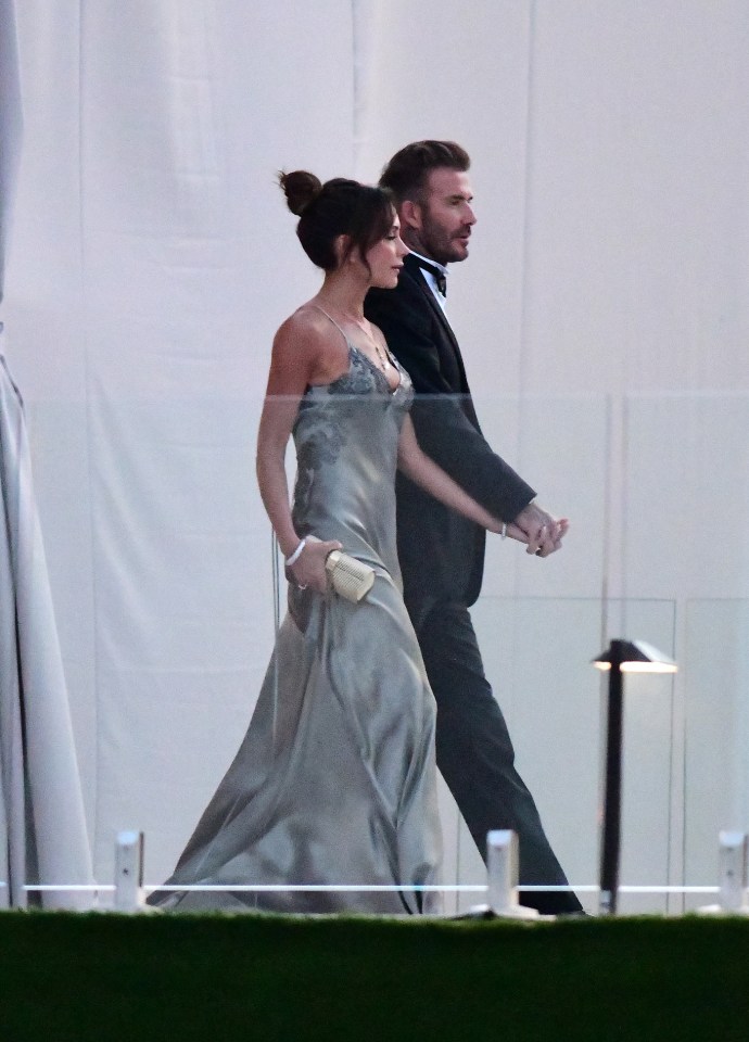 David and Victoria Beckham holding hands.