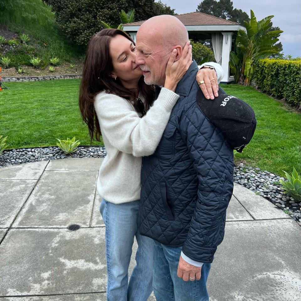 Bruce Willis and Emma Heming embracing.