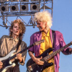 View of New Wave & Pop musicians Robert Holmes, on electric guitar, and Aimee Mann, on bass guitar, both of the group 'Til Tuesday, perform onstage at Liberty State Park, Jersey City, New Jersey, July 4, 1985. (Photo by John Kisch Archive/Getty Images)