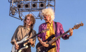 View of New Wave & Pop musicians Robert Holmes, on electric guitar, and Aimee Mann, on bass guitar, both of the group 'Til Tuesday, perform onstage at Liberty State Park, Jersey City, New Jersey, July 4, 1985. (Photo by John Kisch Archive/Getty Images)