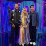 Luke Bryan, Carrie Underwood, and Lionel Richie posing together.