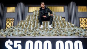 A photo of MrBeast sitting on a pile of cash.
