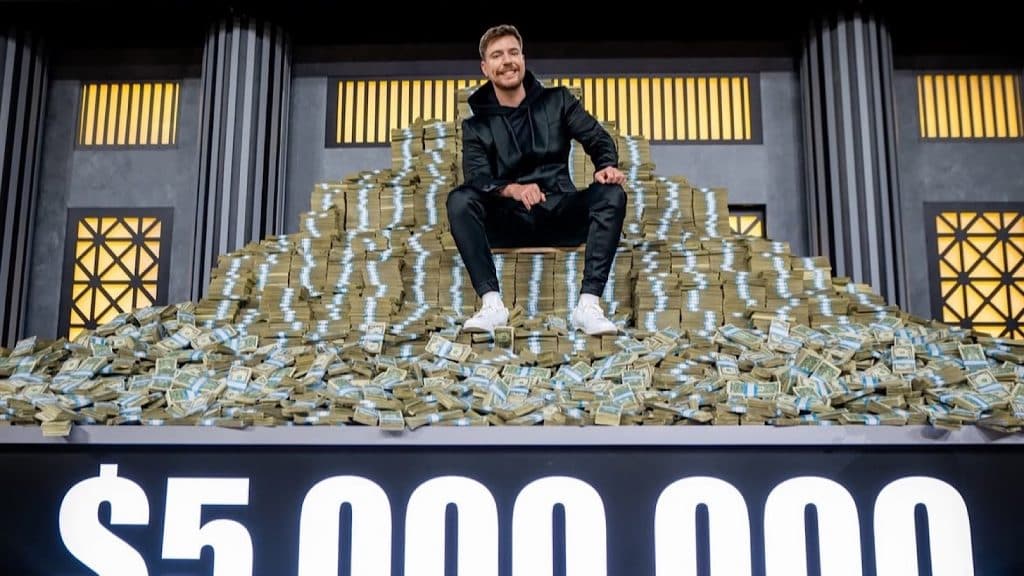 A photo of MrBeast sitting on a pile of cash.