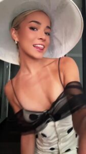 Olivia Dunne at the Kentucky Derby in a white polka dot dress and large white hat.