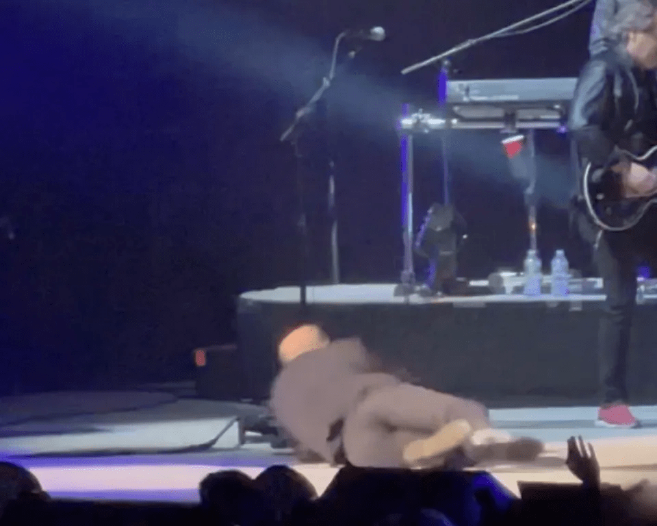 Person falling on stage during a concert.