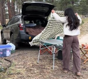 Person setting up a car camping site.