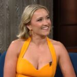 Emily Osment wearing a yellow dress.