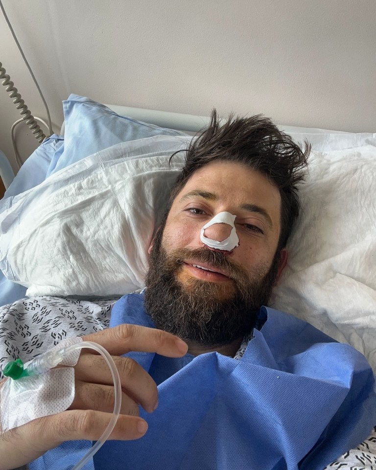 Stanislav Yanevski, a Bulgarian actor, in a hospital bed with an IV and a bandage on his nose.