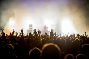 Crowd at a music concert with their hands raised.