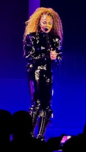 Janet Jackson in a Catwoman-inspired leather outfit on stage.