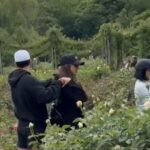 Jessica Alba kissing a man in a garden.