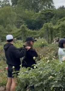 Jessica Alba kissing a man in a garden.