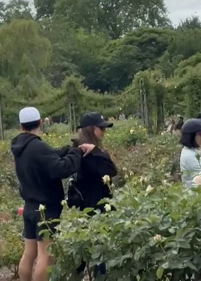 Jessica Alba kissing a man in a garden.