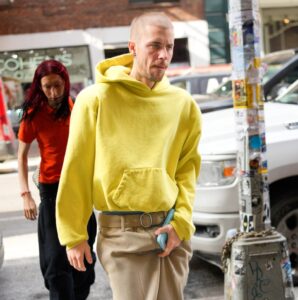 Justin Bieber wearing a yellow hoodie and tan pants in New York City.