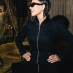 Kris Jenner wearing a black denim zipper jacket and high-rise denim pants.