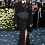 Rihanna at the Met Gala 2025 in a black pinstripe suit and wide-brimmed hat.