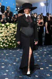 Rihanna at the Met Gala 2025 in a black pinstripe suit and wide-brimmed hat.