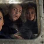Four people sitting together in the cockpit of a massive ahriplane and looking out the window in wonder.