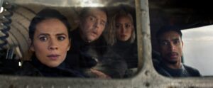 Four people sitting together in the cockpit of a massive ahriplane and looking out the window in wonder.