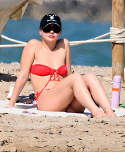 Madelyn Cline in a red bikini on a beach.