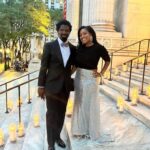 Couple posing on steps lit with candles.