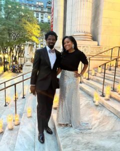 Couple posing on steps lit with candles.