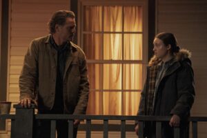 Joel and Ellie stand on a porch