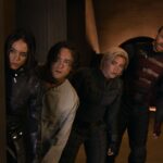 A group of people in superhero costumes peeking out from around a corner.