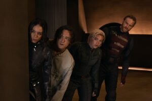 A group of people in superhero costumes peeking out from around a corner.