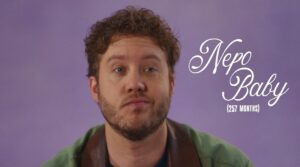 A man with curly hair and a beard against a purple background; text overlay reads "Nepo Baby (257 MONTHS)".