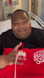 Dave Blunt in a hospital bed, announcing a tour cancellation due to health reasons.