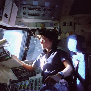 Astronaut Sally Ride monitors control panels from the pilot's chair on the flight deck of the Space Shuttle Challenger. June 25, 1983.