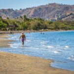 retired man walking along the beach in costa rica