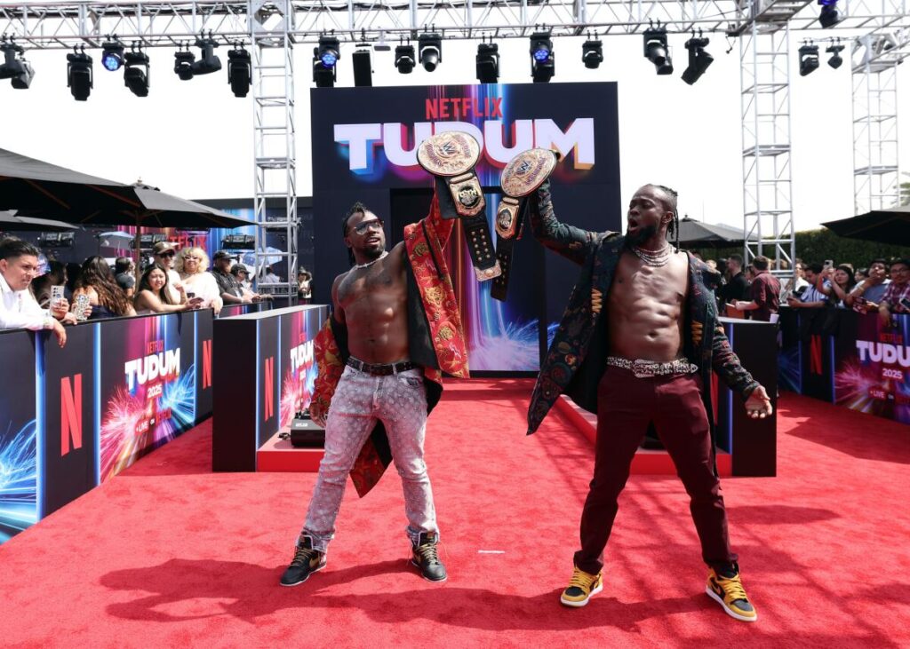 Xavier Woods and Kofi Kingston hold up big belts
