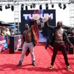 Xavier Woods and Kofi Kingston hold up big belts