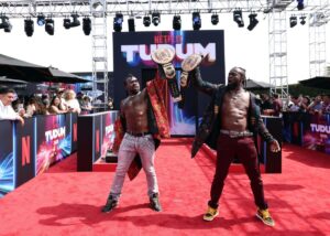 Xavier Woods and Kofi Kingston hold up big belts