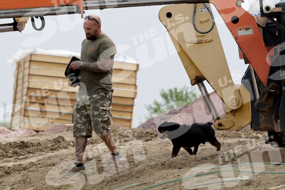Adam Lind walking with his dog at a construction site.