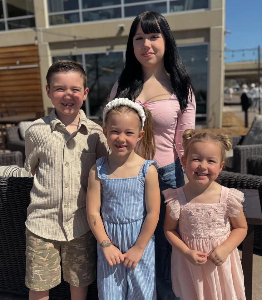 A woman and her three children posing for a photo.