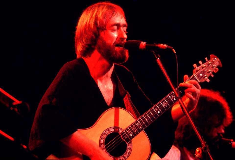 Dave Mason performing with an acoustic guitar.