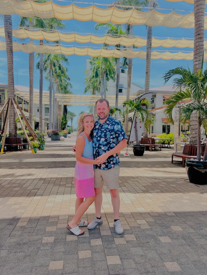 Couple posing under a shaded walkway.