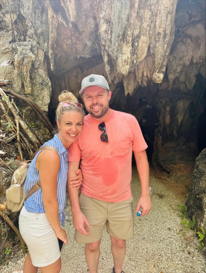 Couple posing in front of a cave.