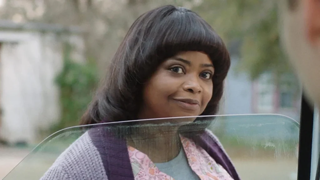Octavia Spencer with an unflattering haircut looks into a ca window in Ma