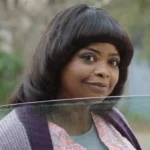 Octavia Spencer with an unflattering haircut looks into a ca window in Ma