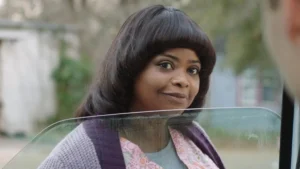Octavia Spencer with an unflattering haircut looks into a ca window in Ma
